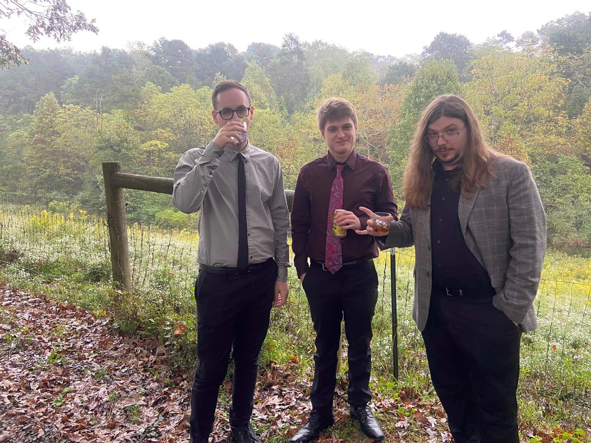 Individually Twisted band members in formal wear while holding drinks